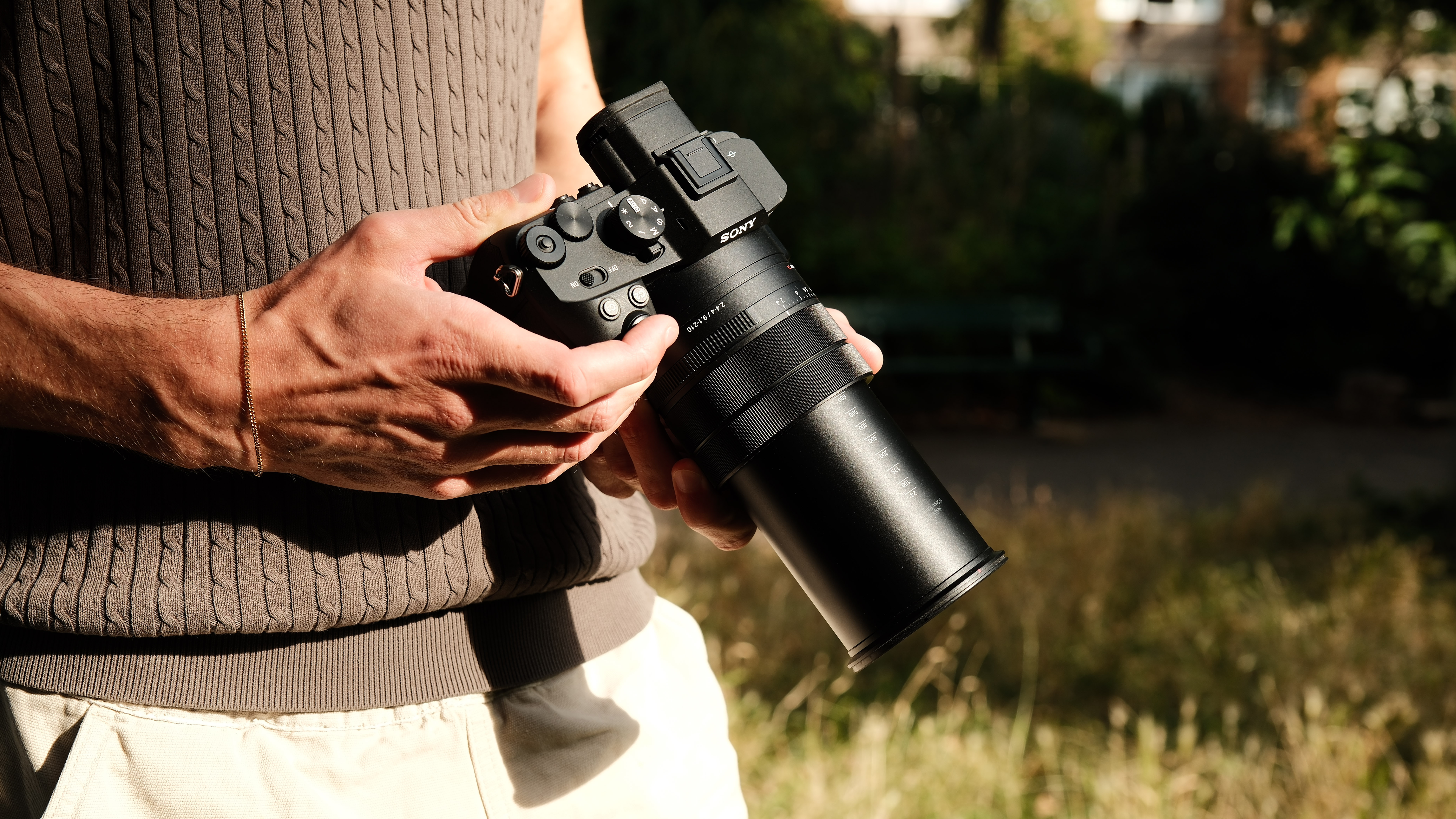 Person holding the Sony RX10 V with its long zoom lens fully extended.