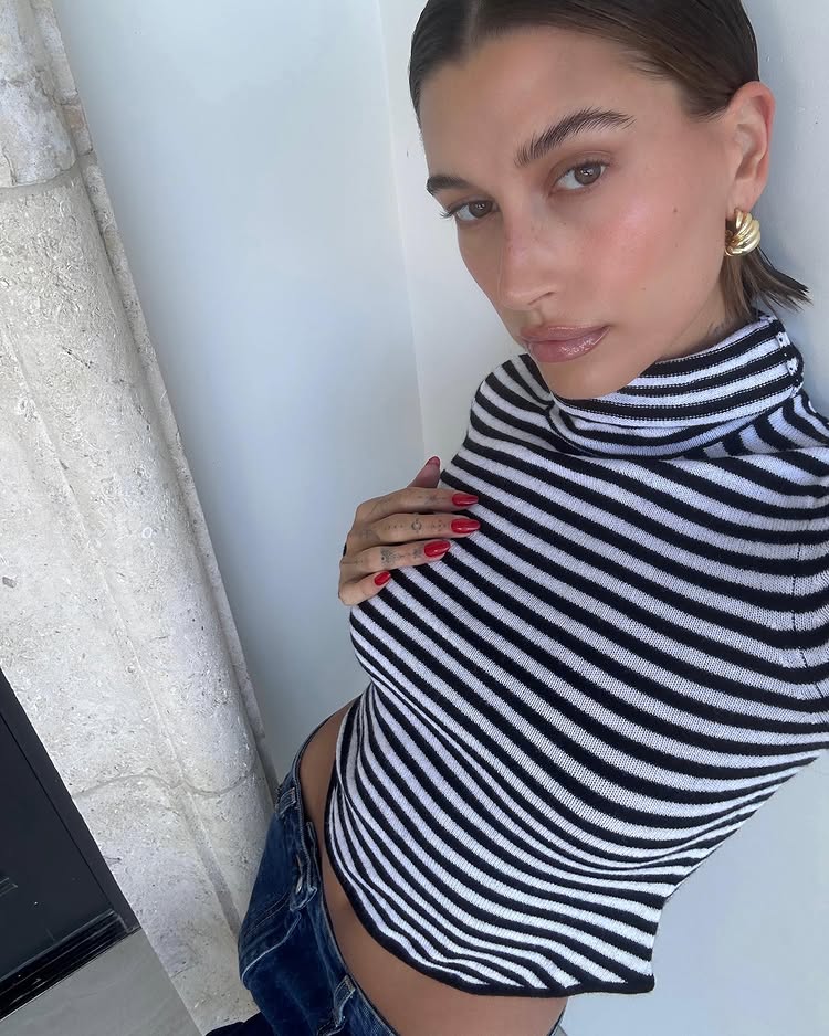An image of Hailey Bieber wearing a striped turtleneck top from Hesla.