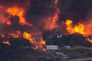 Flames sweep through a rural community at the Blue Cut Fire on Aug. 17, 2016, near Wrightwood, California. 