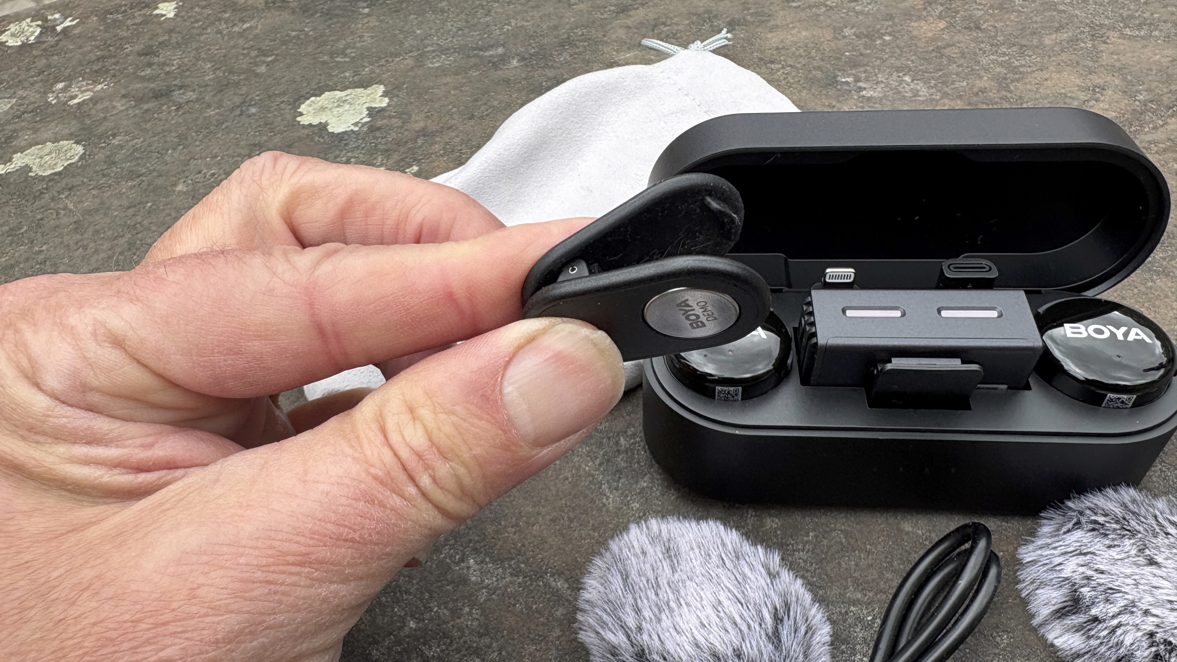 Close-up of a hand holding a springed-clip mic attachment