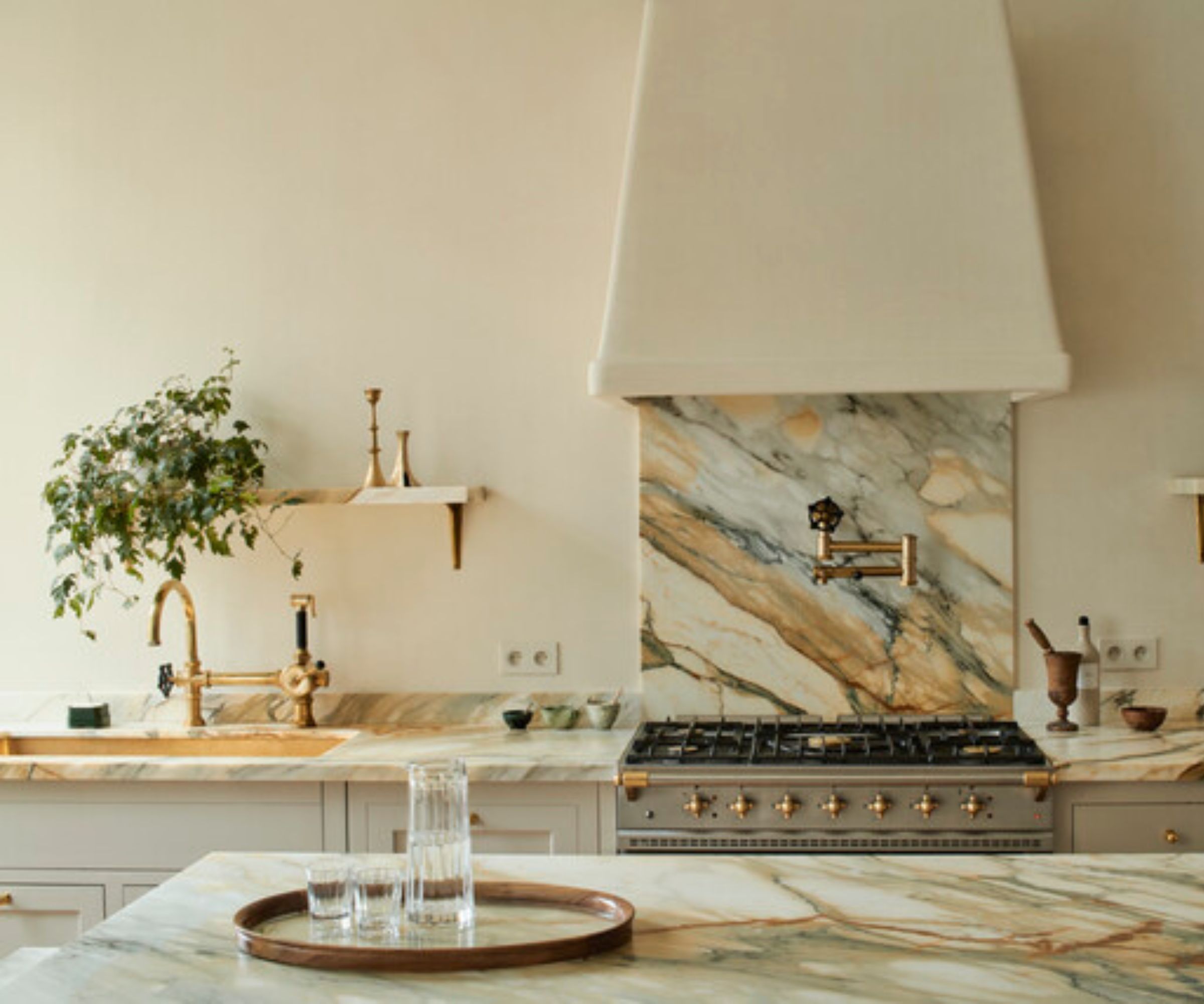 A warm white kitchen with strongly veined stone countertops