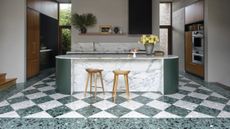 A kitchen with green and white marble island, and gren chequerboard flooring