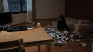 Moon Dong-eun (Song Hye-kyo) among a pile of photographs in The Glory Part 2