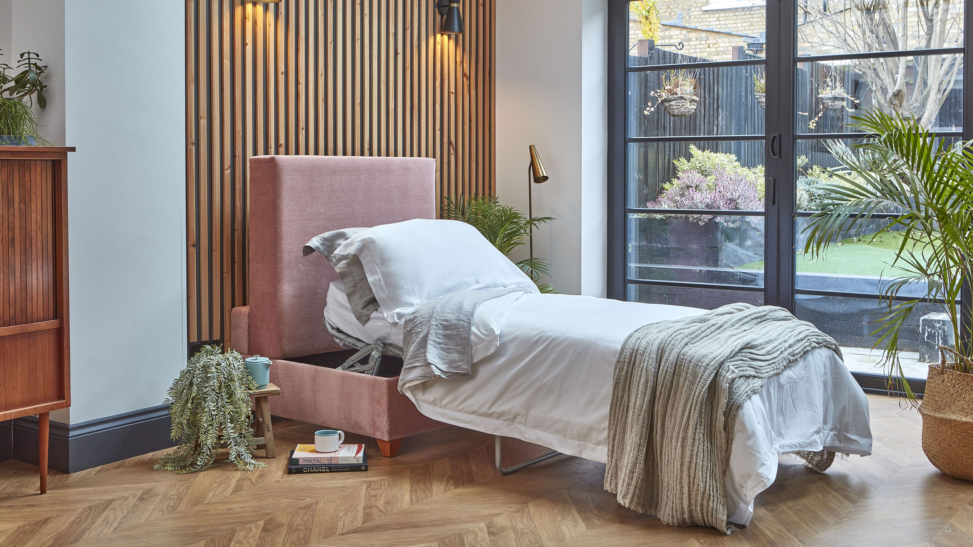 guest bedroom in conservatory with metal French doors and herringbone wooden flooring