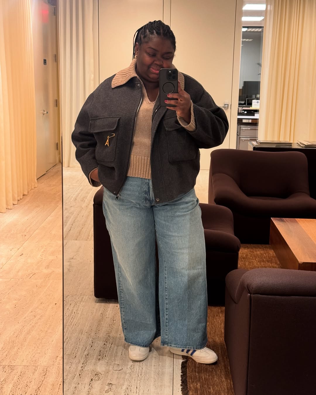 Influencer Abi Marvel wearing wide-leg jeans, v-neck jumper, bomber jacket and trainers.
