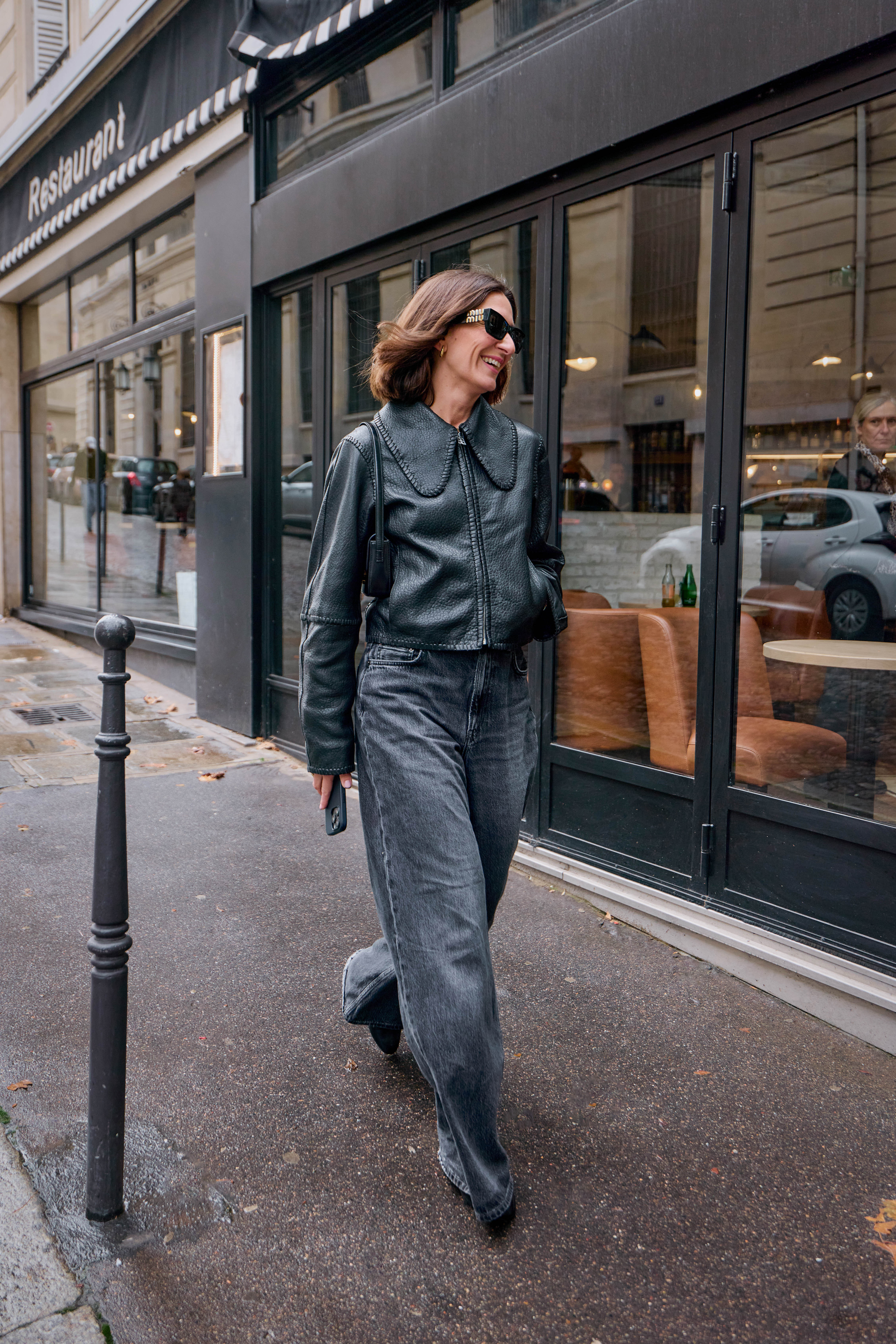 Woman in black jeans, black boots, and black leather jacket.