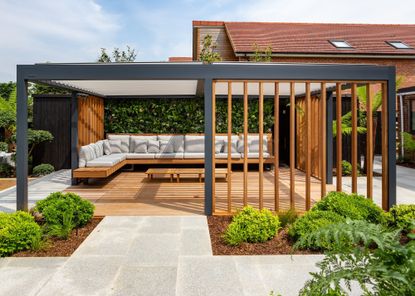 A bespoke pergola with roof and integrated timber side screens on a deck