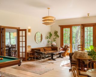 Rustic open plan living room with wooden seating, wooden architectural features, wooden floor, houseplants