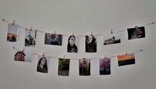 photos on a string on a white wall