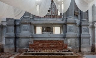 white cloths and black benches in vast venice hall