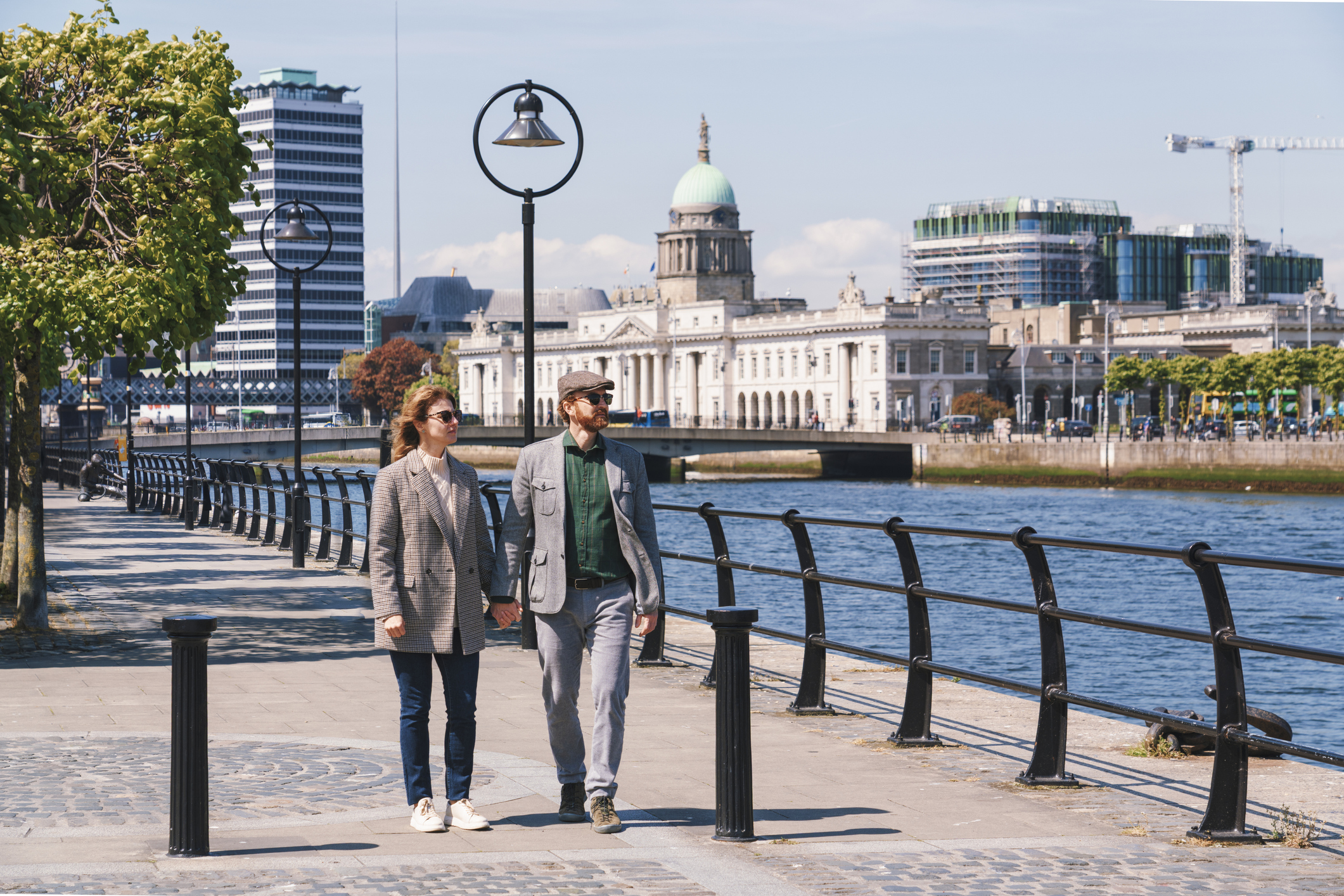 A couple strolls along the Liffey River in the heart of Dublin City, Ireland