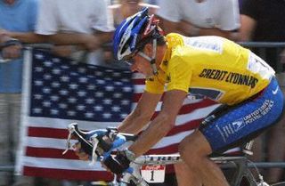 Lance Armstrong (USPS) rides past a US flag near the Arc de Triomphe during the last stage