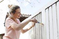 woman painting a fence