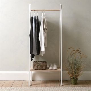 White and wooden clothes rail with clothes