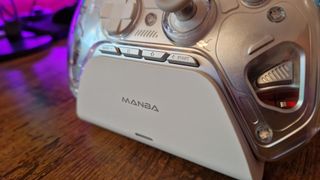 A Manba One review image showing the charging stand an options buttons of the controller