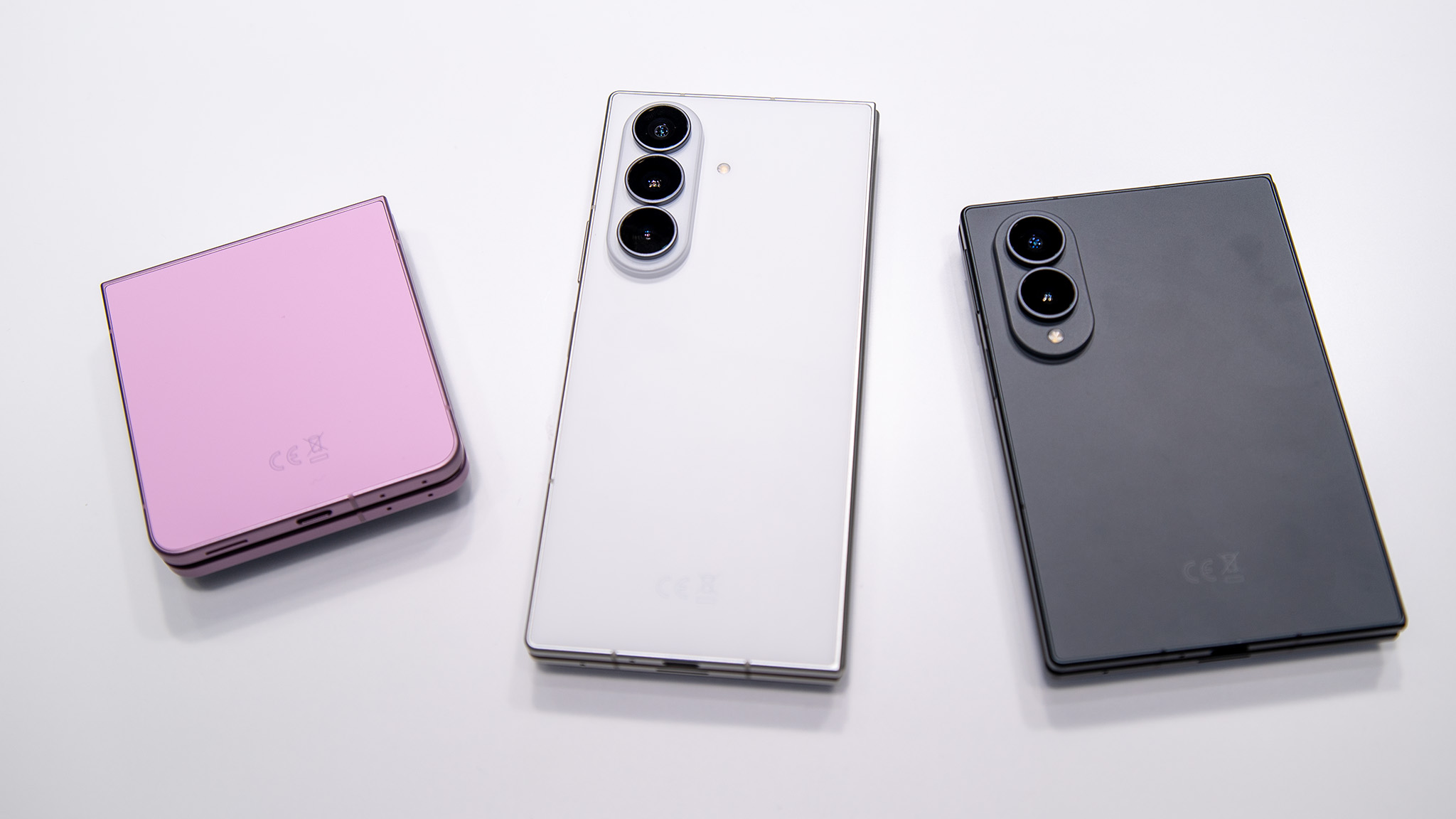 Comparing the sizes of the Samsung Galaxy Z Flip 8 (pink) with the white Galaxy Z Fold 8 Ultra and grey Galaxy Z Fold 8