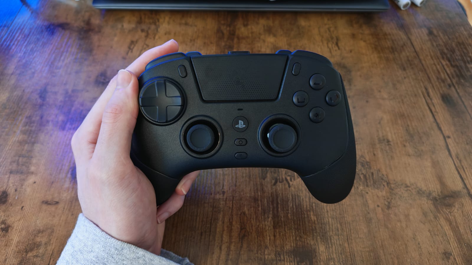 A reviewer holding the Razer Raiju V3 Pro