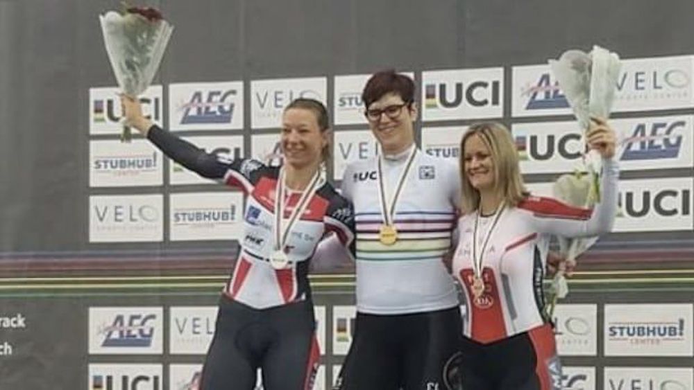 Rachel McKinnon on the Masters Worlds podium with her rainbow jersey