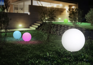 impressive globe lights in a modern outdoor garden with a house in the background