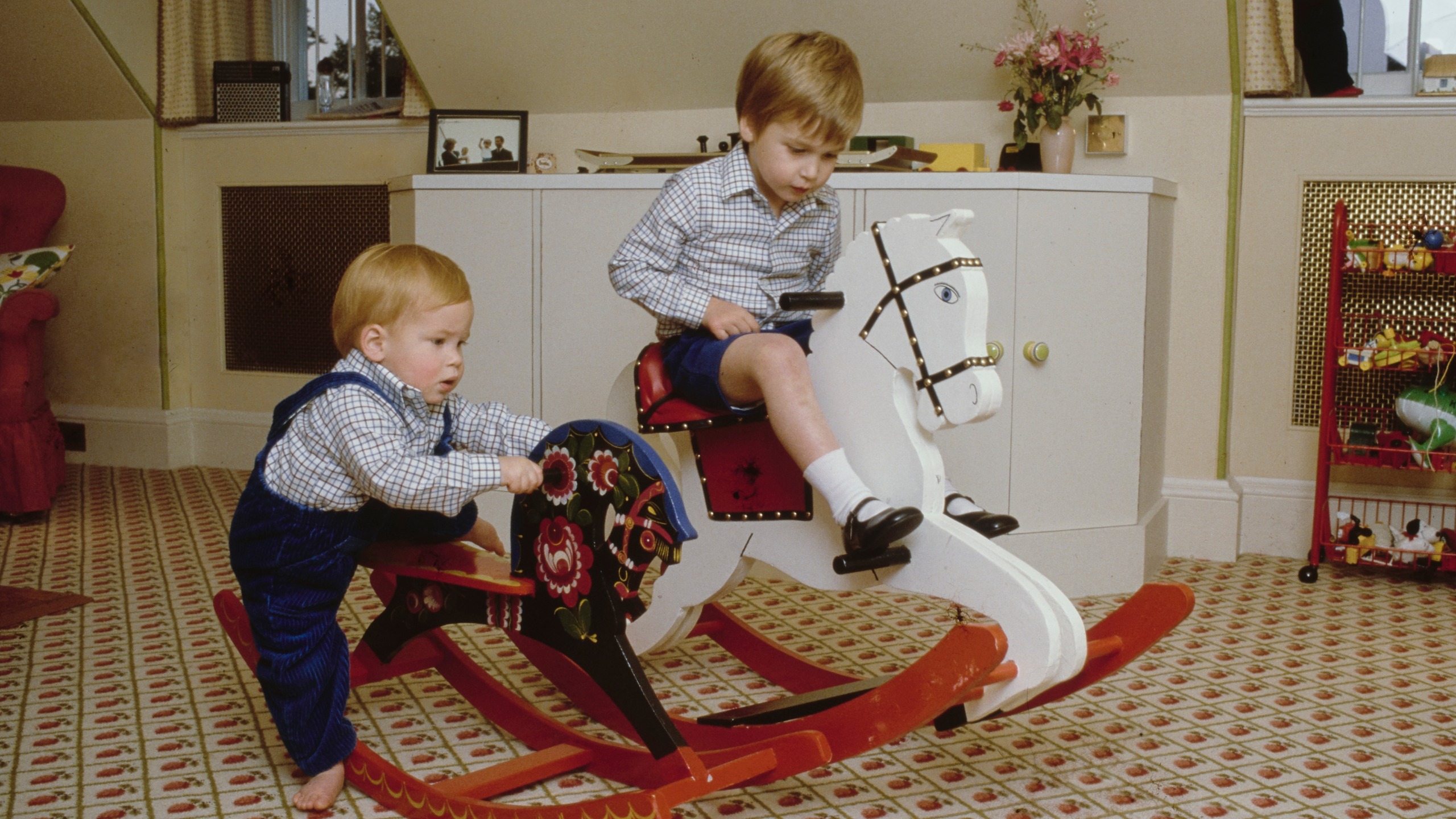 Prince Harry and Prince William play on their rocking horses at their home in Kensington Palace, London, England, 22nd October 1985