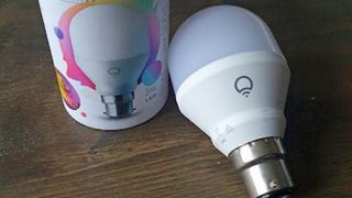 LIFX Color Smart Bulb on wooden surface next to packaging in writer's home