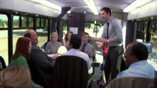 The Office characters sitting in the work bus together.