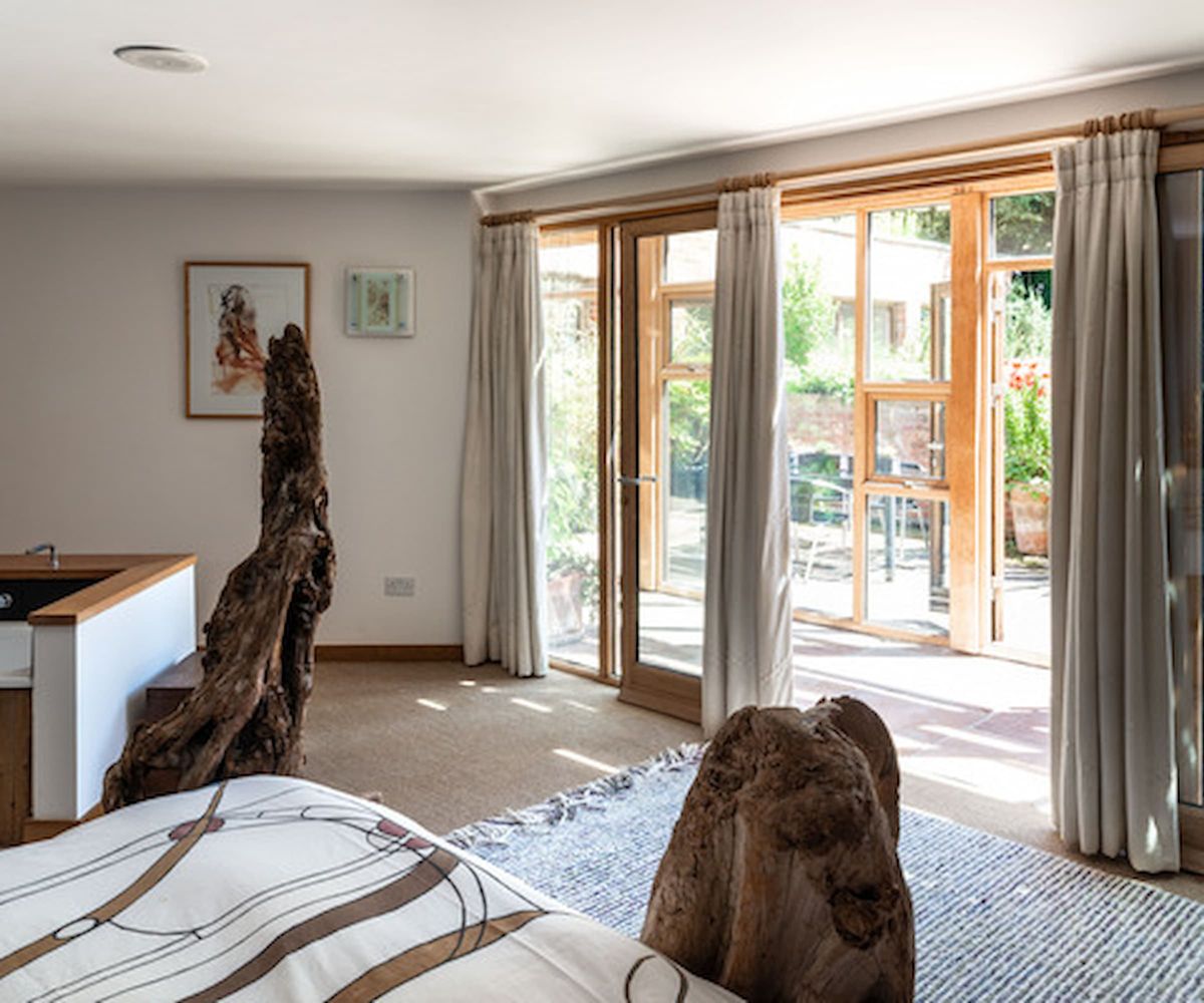 A bedroom connected to a wooden framed conservatory