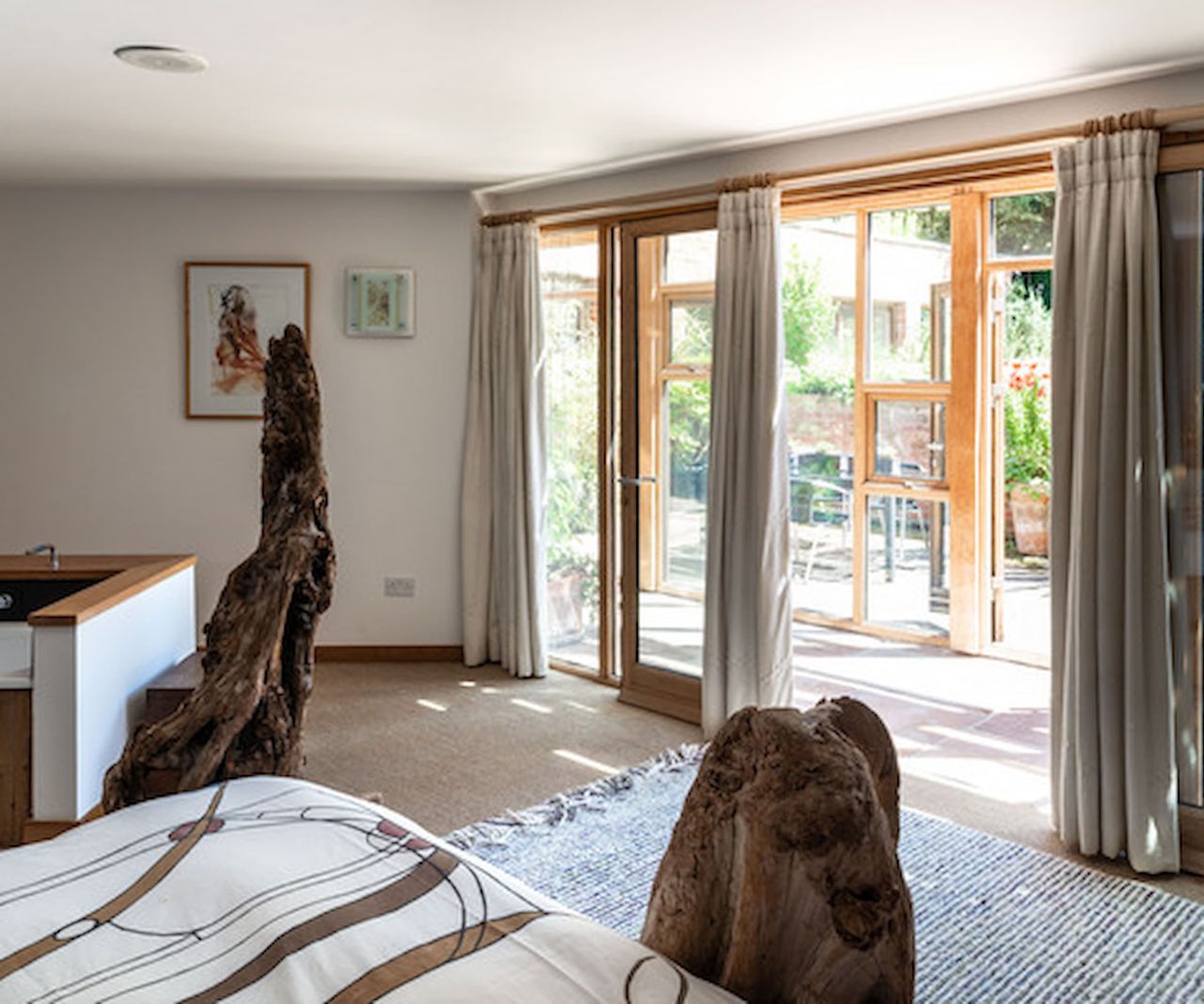 A bedroom connected to a wooden framed conservatory