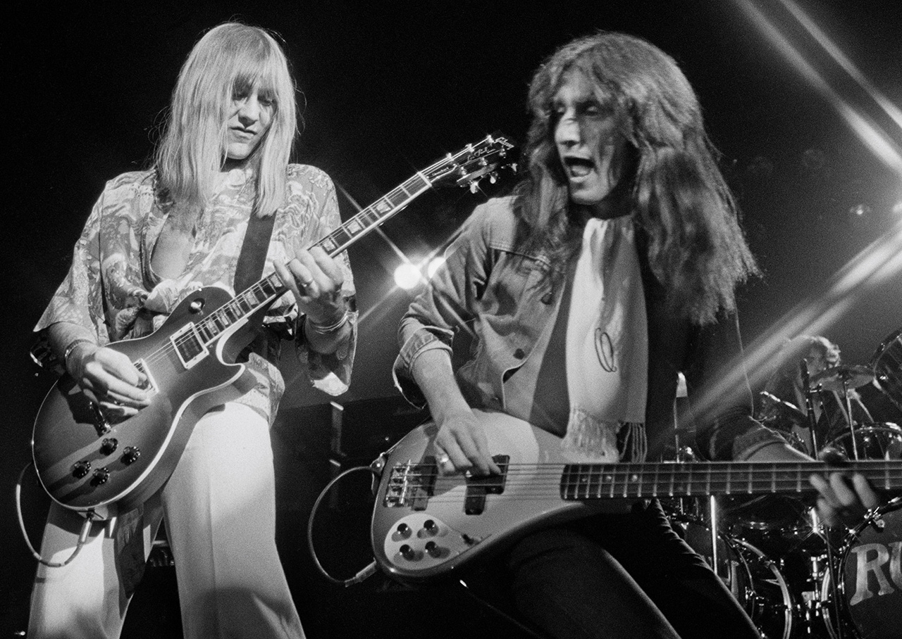 Alex Lifeson and Geddy Lee from Canadian group Rush perform live on stage in Springfield, Massachusetts 9th December 1976 during their All The World's a Stage tour. (Photo by Fin Costello/Redferns)