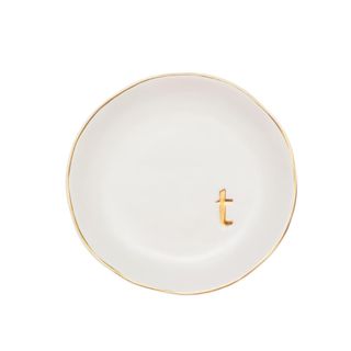 A white trinket tray with gold edges and a gold 't'