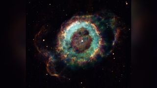 The Little ghost nebula's main round structure is about a light-year across and the glow from ionized oxygen, hydrogen, and nitrogen atoms are colored blue, green, and red respectively.