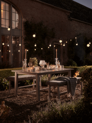 An example of how much does outdoor lighting cost showing outdoor festoon lighting in a dining area