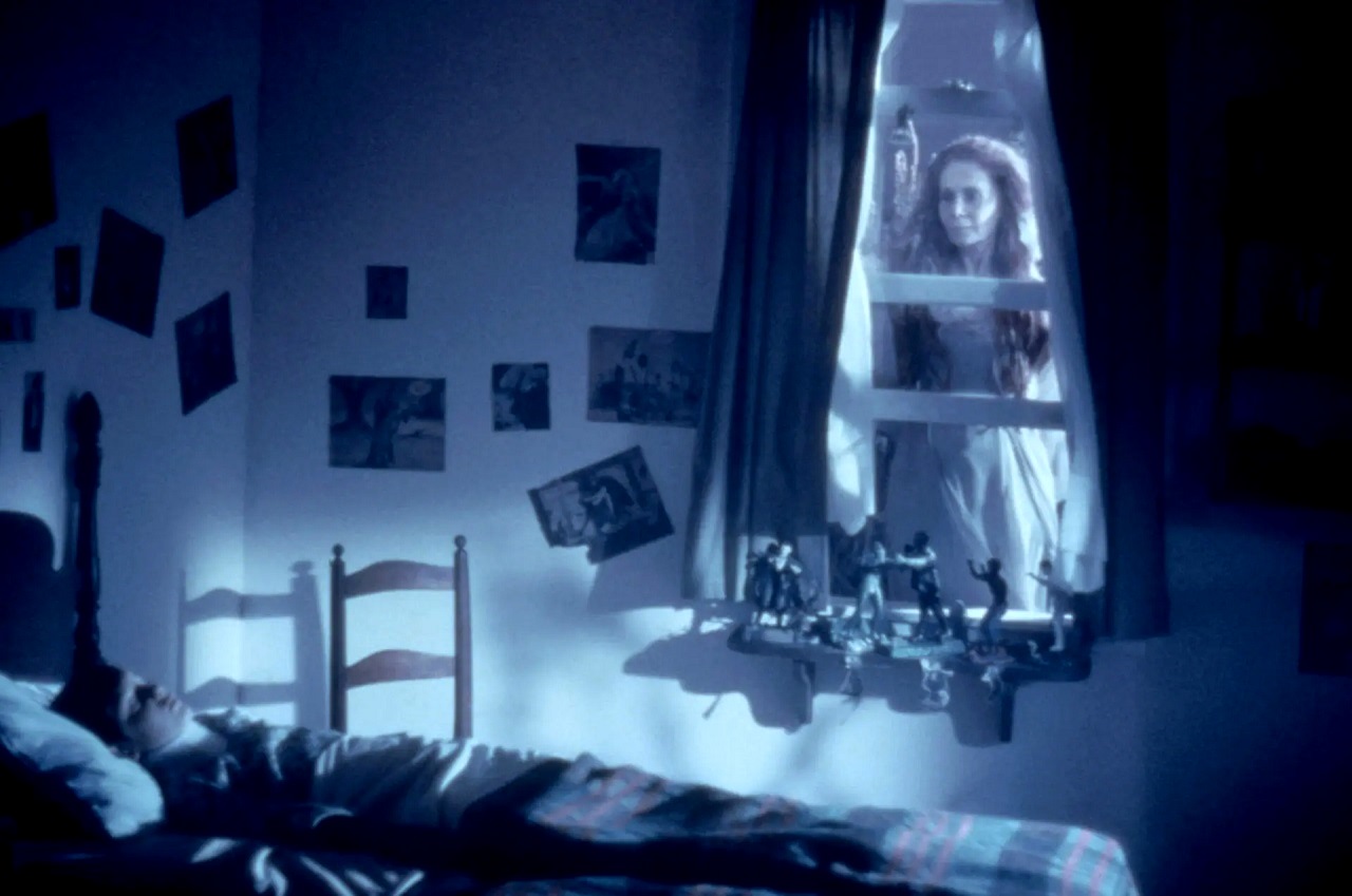 lukas haas sleeps while a young girl ghost looks through the window in the movie lady in white