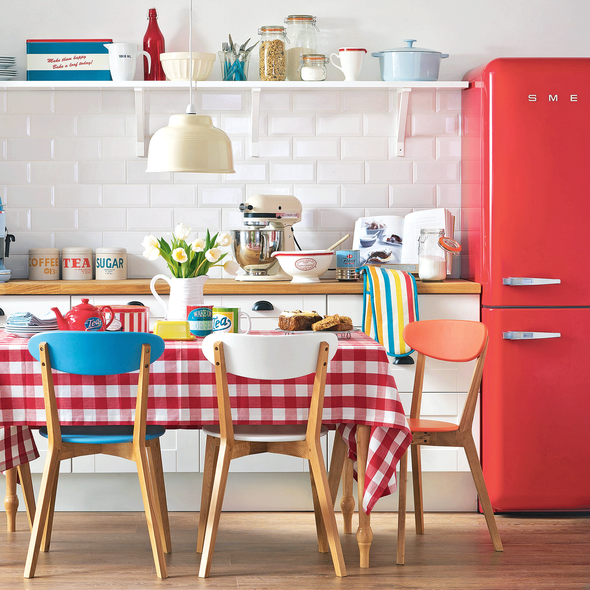 Red fridge freezer in a kitchen with wooden table