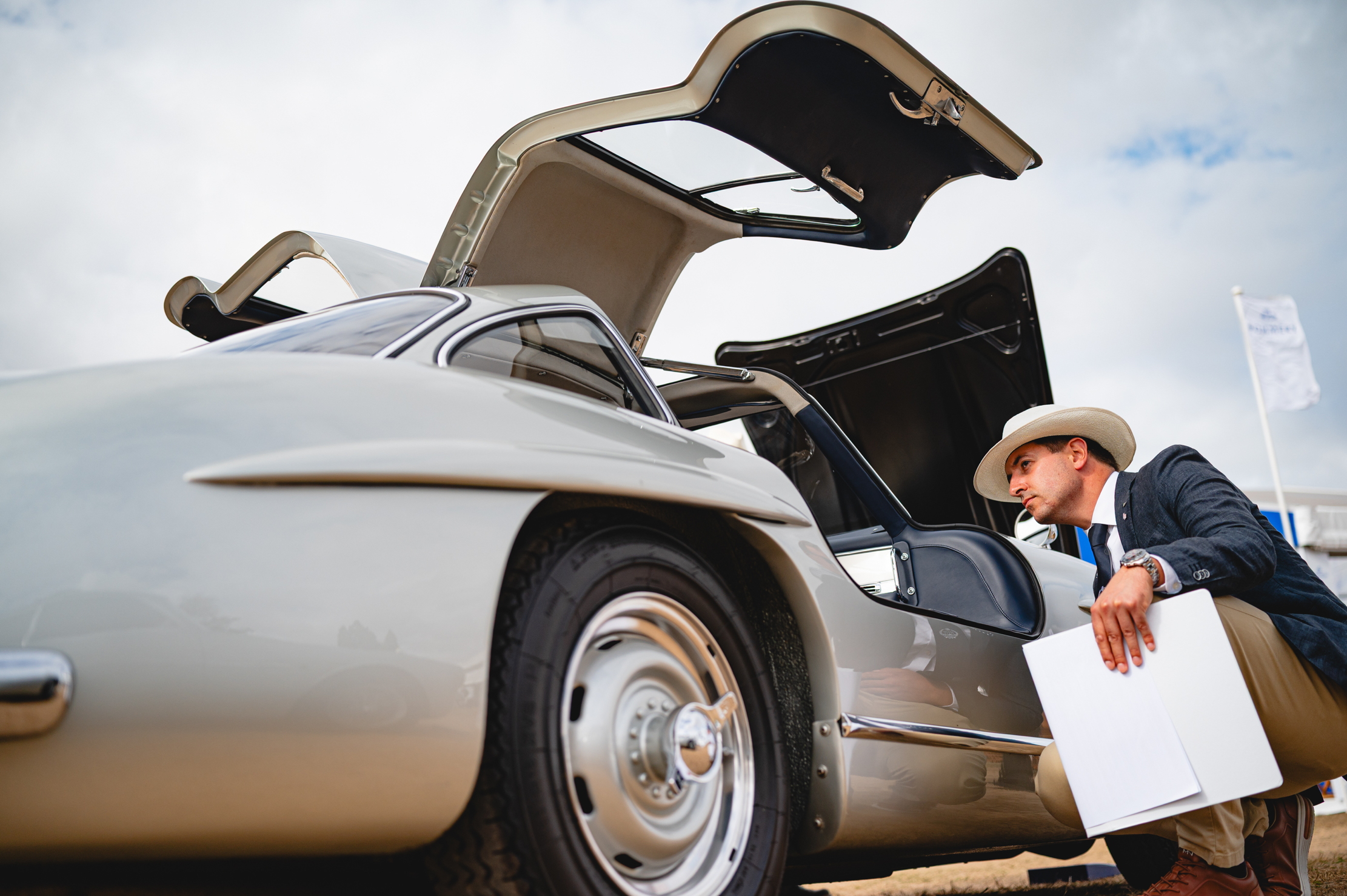 A judge inspects a 300SL Gullwing