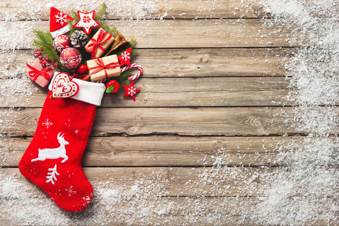 Stocking fillers ideas: Christmas stocking and toys over rustic wooden background