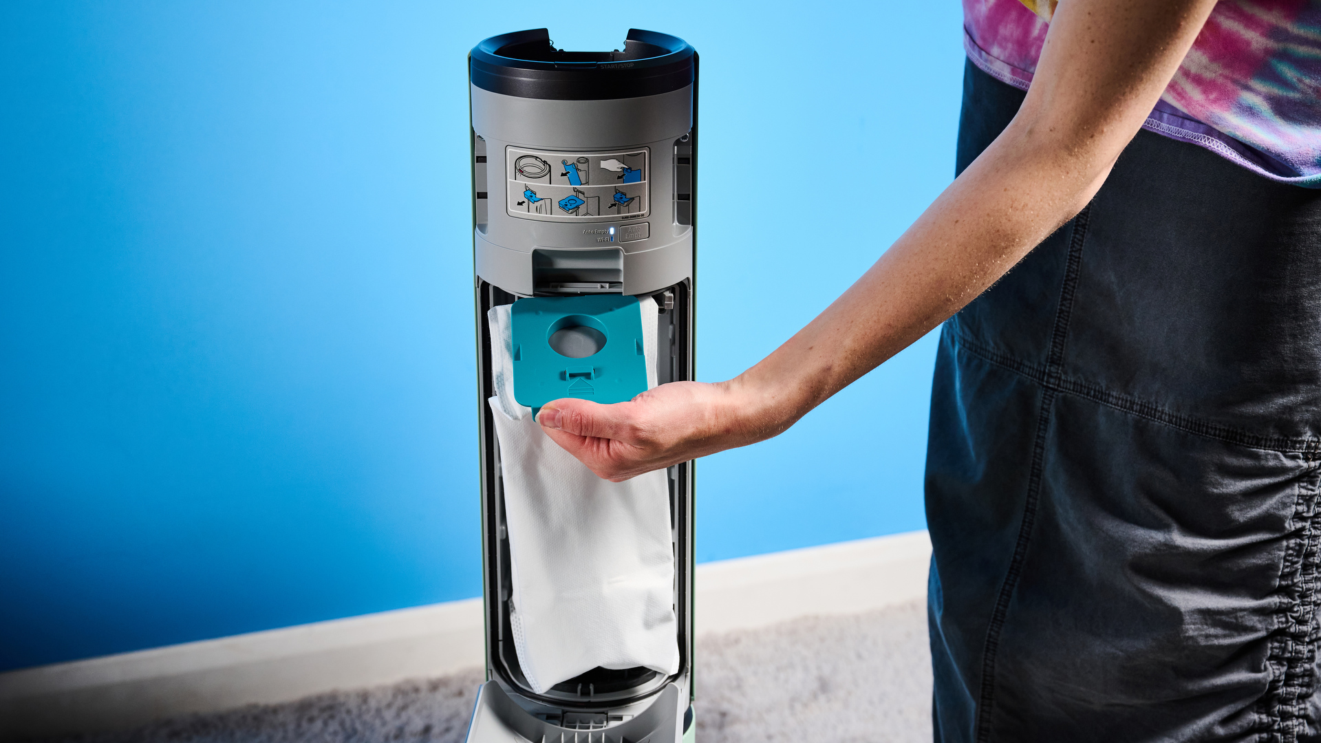 the samsung bespoke jet AI vacuum cleaner in mint green against a blue background, showing its ability to clean carpets and baseboards, as both a stick and a handheld