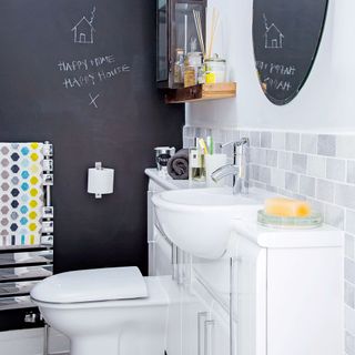 bathroom with chalkboard painted wall and commode