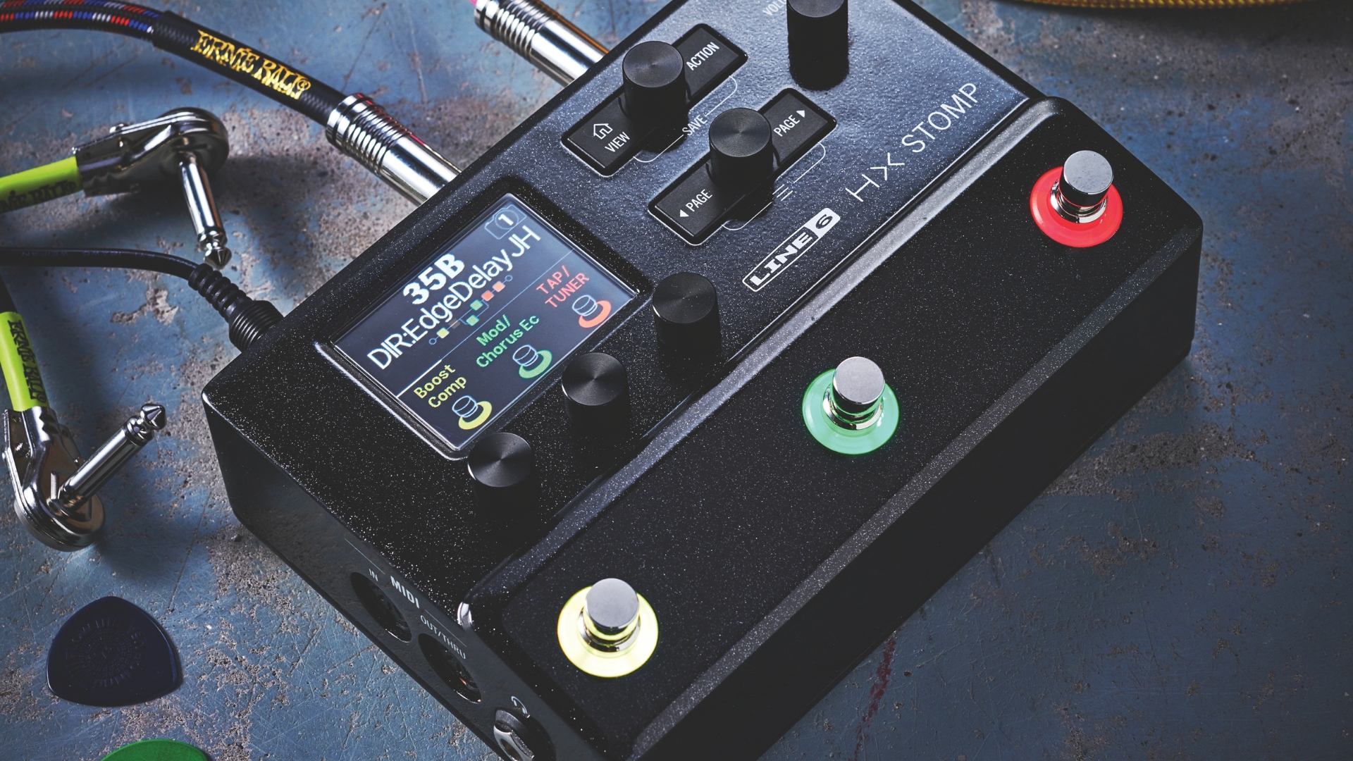 A Line 6 HX Stomp pedal amp on a concrete floor with some guitar accessories