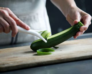 how to get rid of silverfish - a woman peeling cucumber - Unsplash
