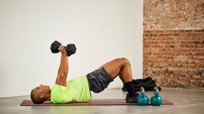 Man performing a dumbbell glute bridge