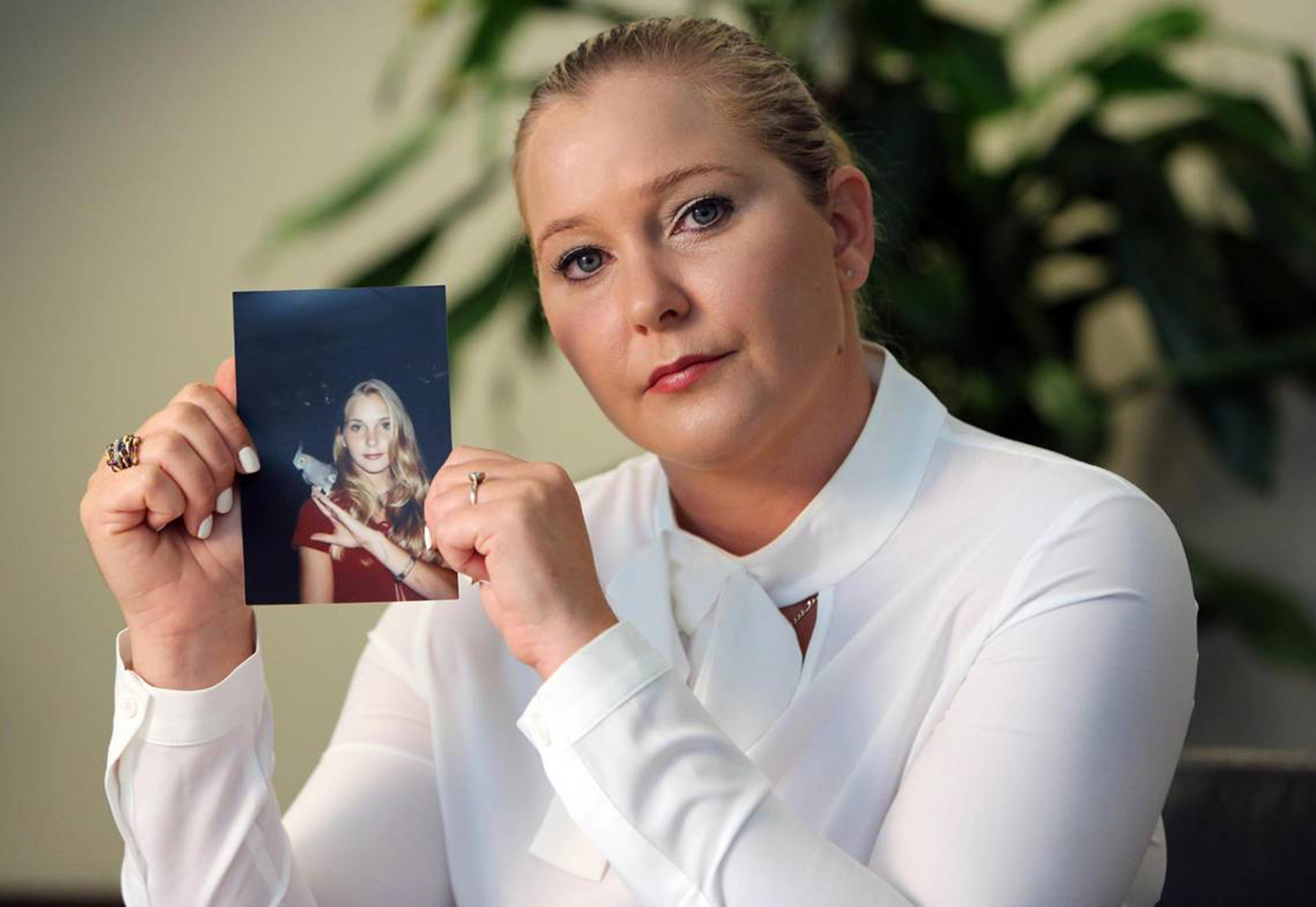 Virginia Giuffre, with a photo of herself as a teen, when she says she was abused by Jeffrey Epstein, Ghislaine Maxwell and Prince Andrew, among others.