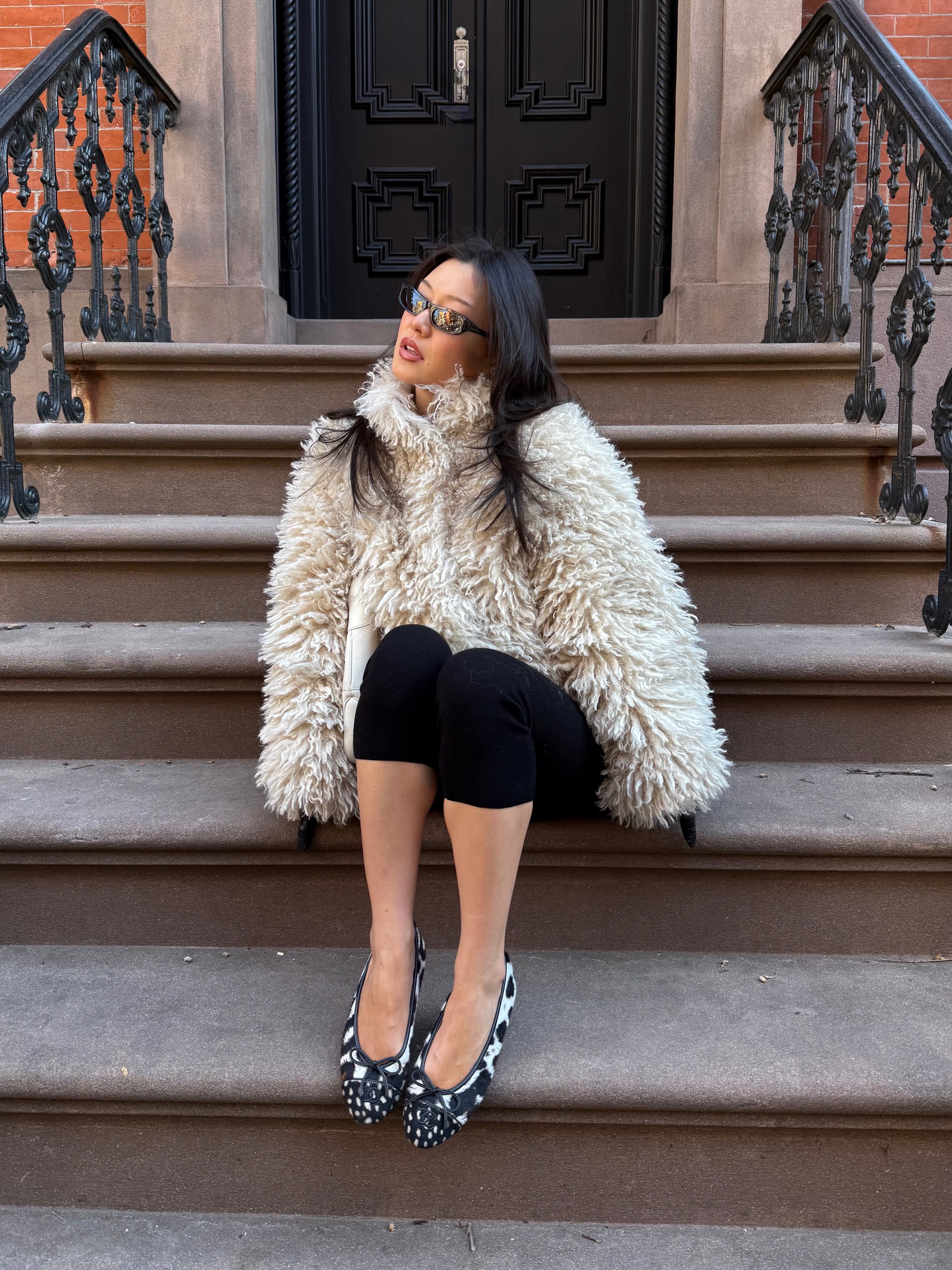 new york city fashion content creator Carolyn Chang wearing the black, white, and brown leopard and deer print pony hair flats by Chanel.