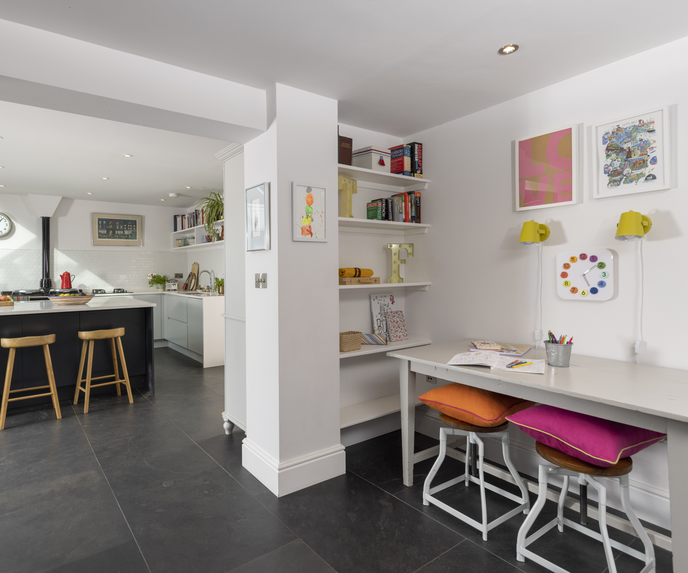 desk area created to side of kitchen with two colourful stools