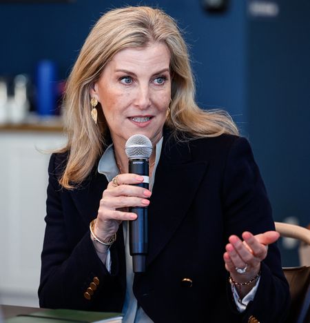 Duchess Sophie wearing a blue blazer speaking into a mic while sitting at a table