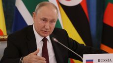 Vladimir Putin sitting in front of African flags