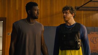Sinqua Walls and Jack Harlow as Kamal and Jeremy staring at each other on a basketball court in White Men Can't Jump