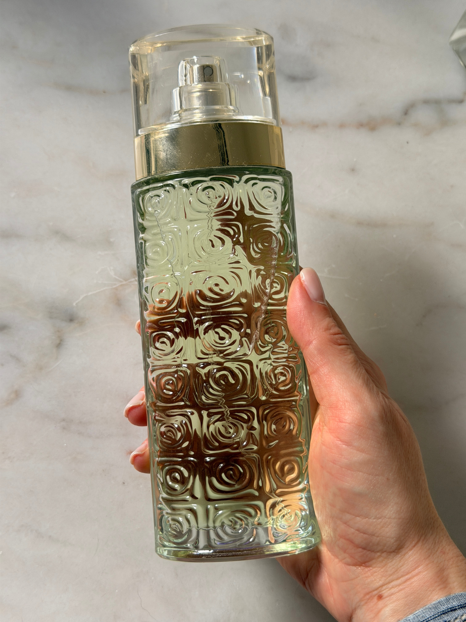 Grace holding a bottle of Lancome perfume