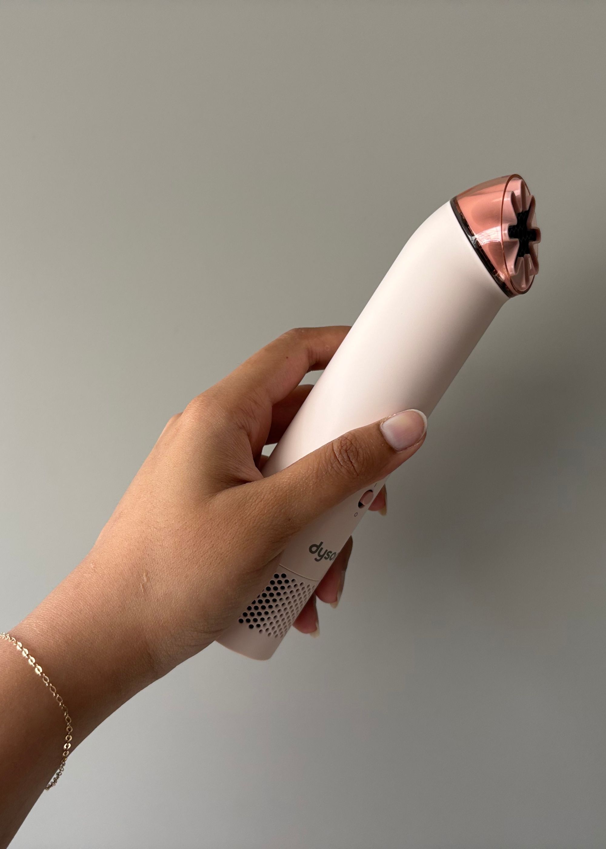 A hand holding the Dyson HushJet Mini Cool Fan