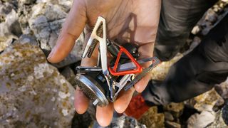 The Primus MicronTrail camping stove for backpacking pictured sitting in a male backpackers hand